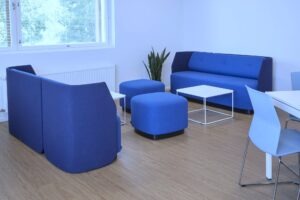 kaksi sohvaa vastakkain, välissä sohvapöytä ja rahit. takana ikkuna