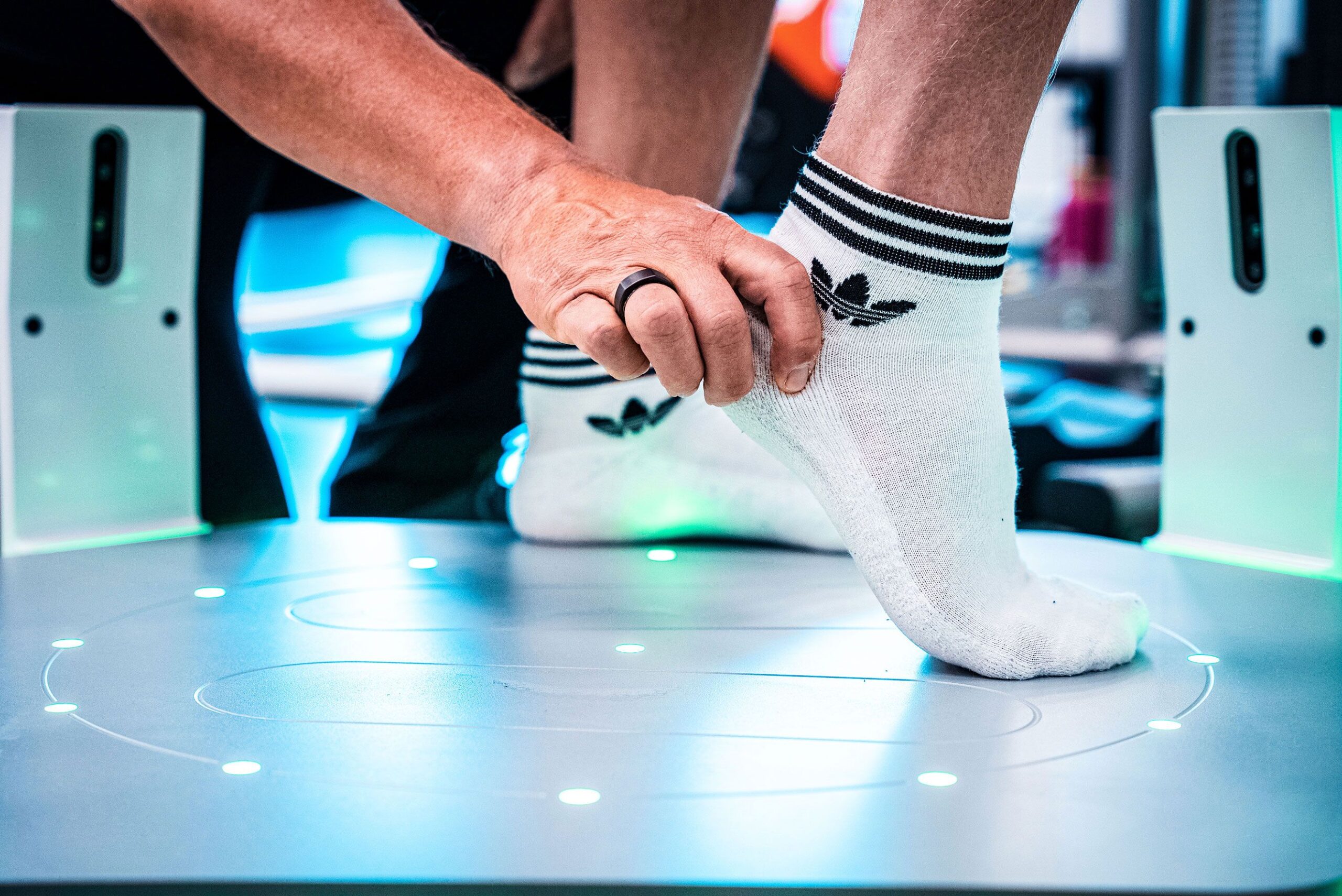 Ihminen seisoo pöydällä ja hänen nilkkansa ovat lähikuvassa. Toinen jalka on varpaillaan ja siitä pidetään käsin kiinni